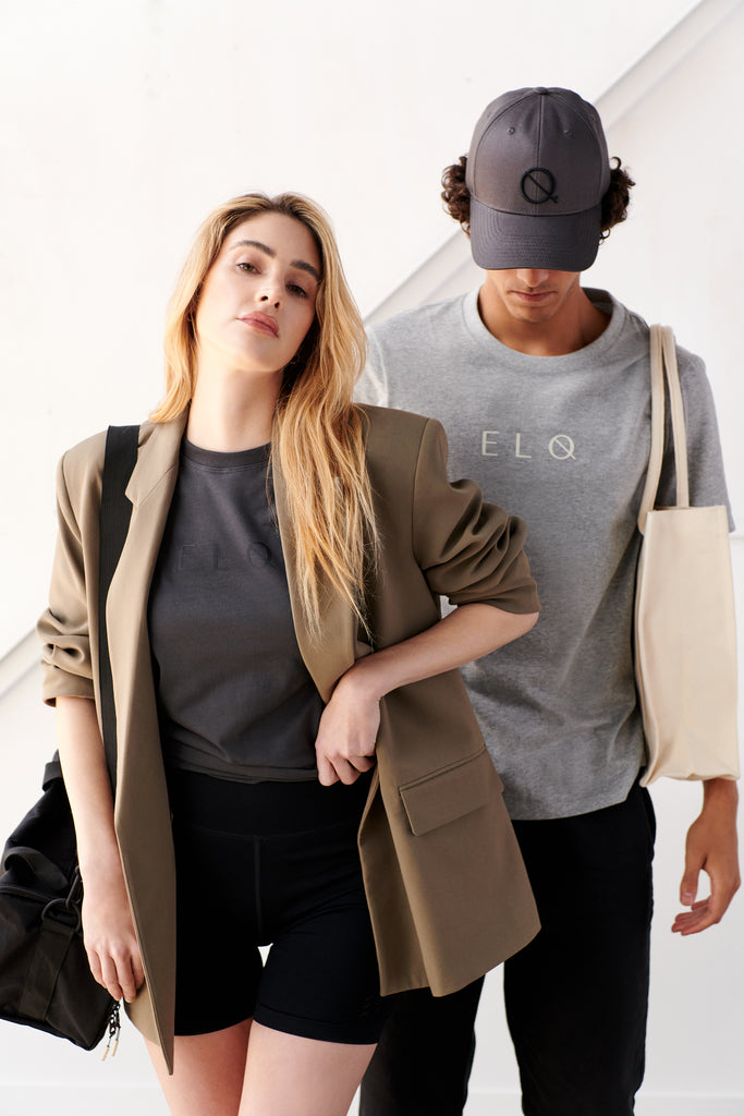 Male and female model wearing black crossbody sports bag, canvas tote bag and vintage black cap