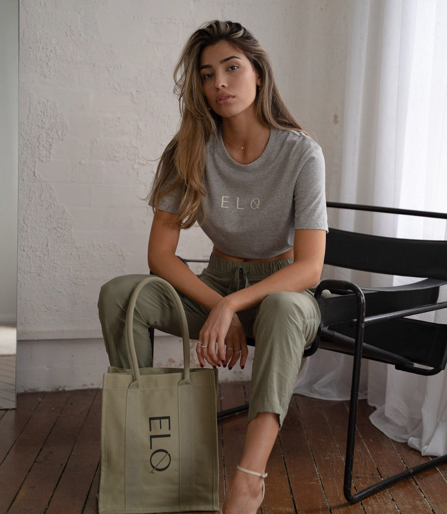 Female model wearing grey womens tee and khaki green canvas tote bag