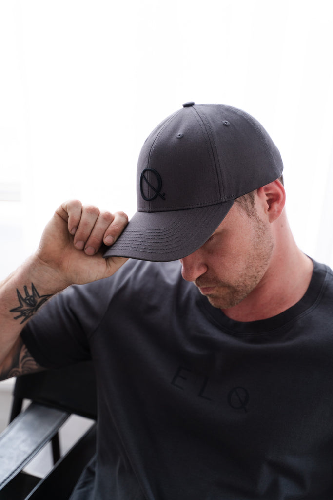 Model wearing ELQ Active Icon vintage black cap baseball with embroidered logo