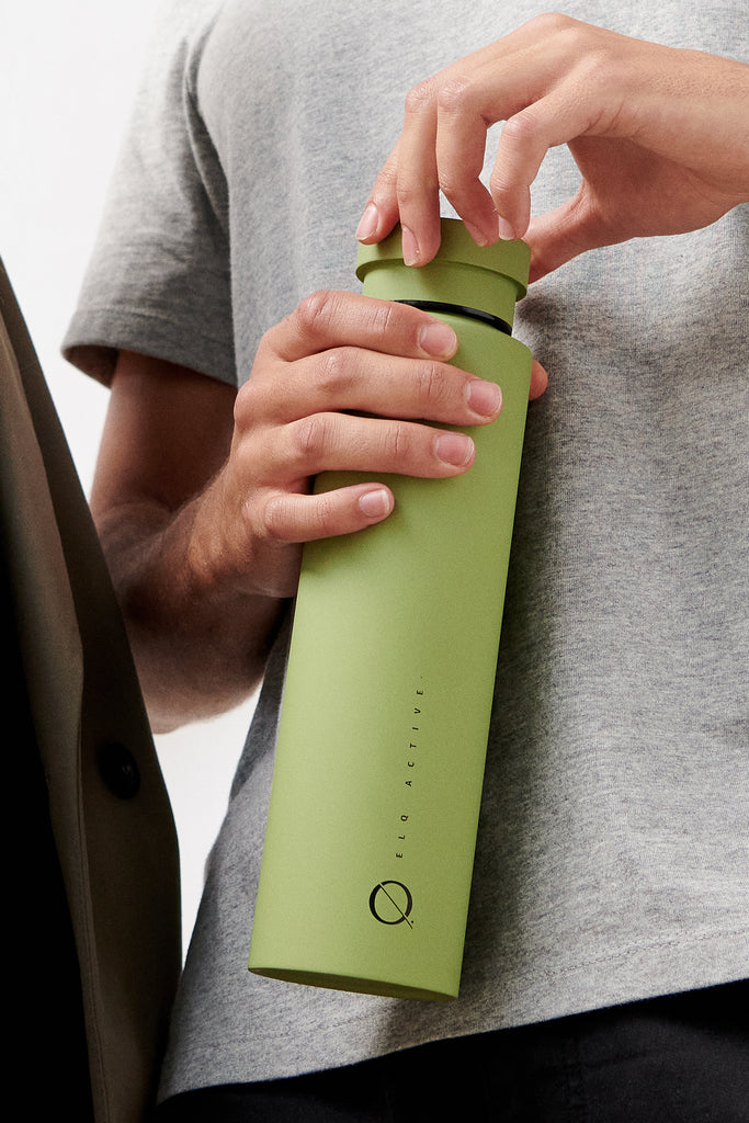 Model holding stainless steel water bottle in green